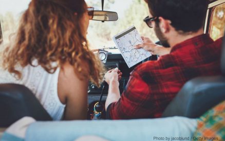 a man and woman in a car looking at a map