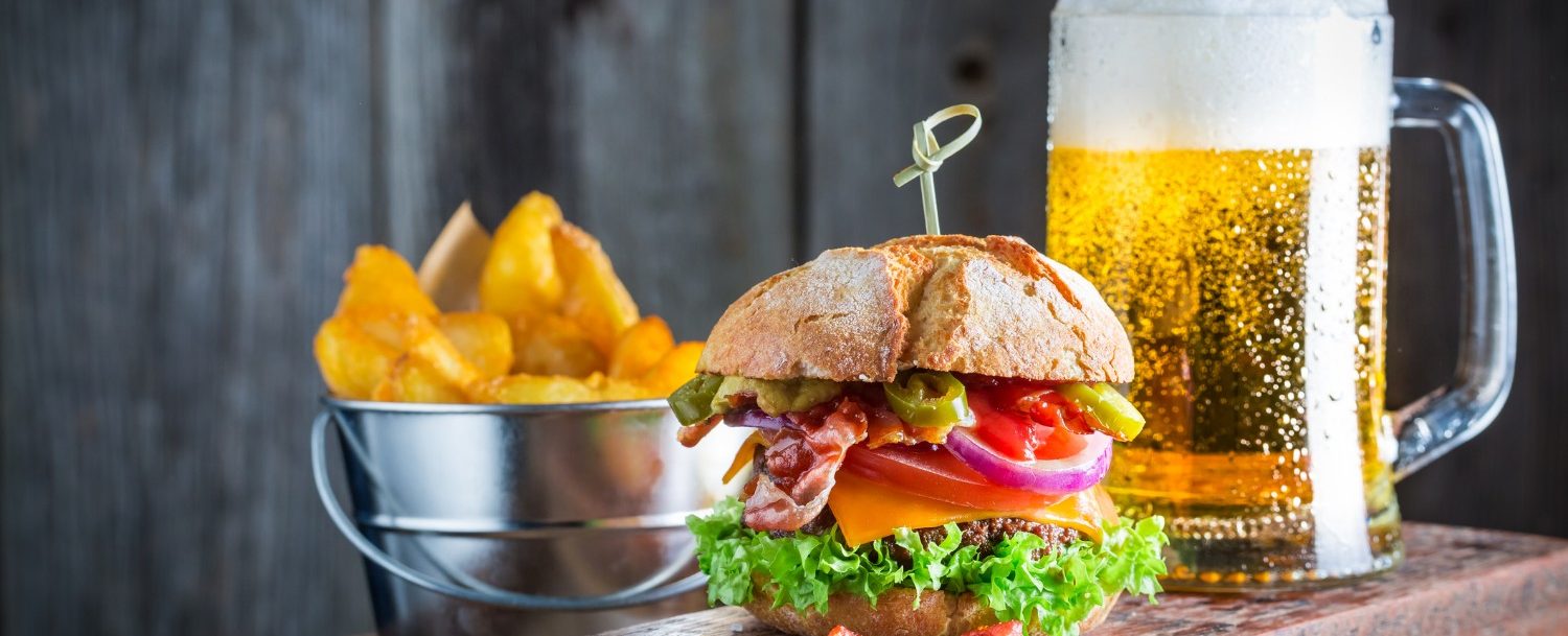 Beer and fresh hamburger made of beef, cheese and vegetables
